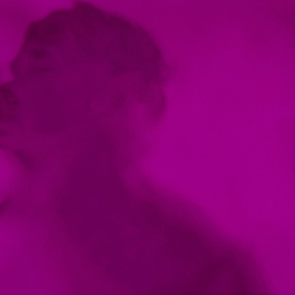 Imagen en duotono violeta y magenta de un equipo colaborando frente a una pantalla con listados